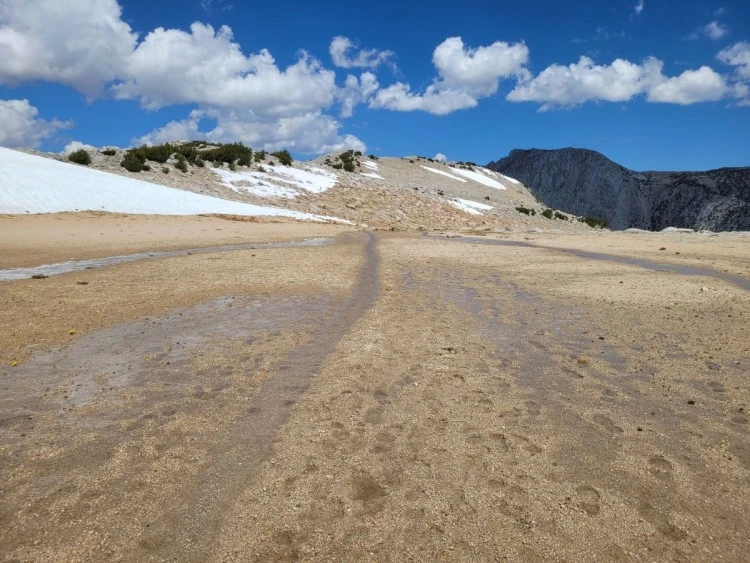 Meltwater on the sandy ground beyond the pass.